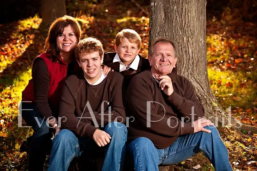 Family of four in autumn outdoor image.